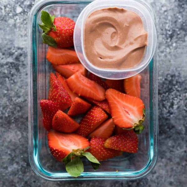 overhead shot of cut strawberries with greek yogurt dip in container