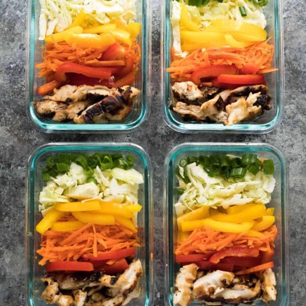 four glass meal prep containers with satay chicken lunch bowls
