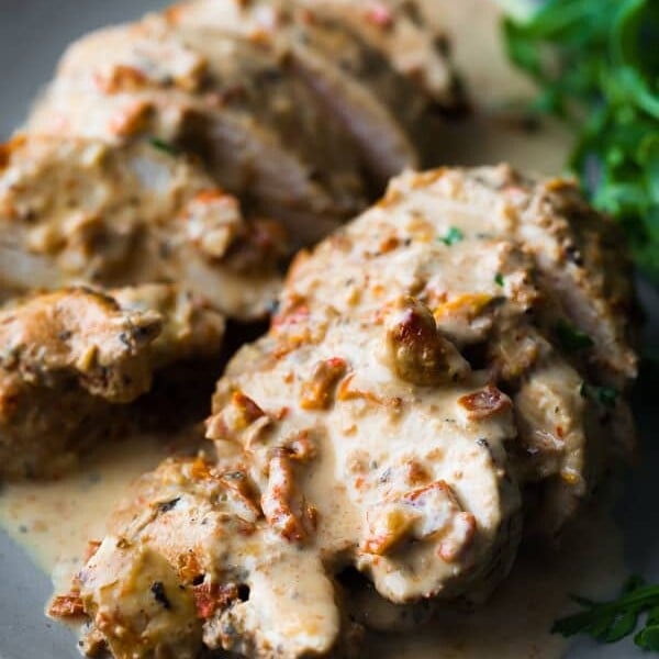 close up shot of chicken breasts sliced with sun dried tomato cream sauce