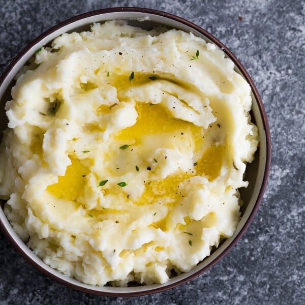 overhead shot of herb and garlic instant pot mashed potatoes in brown bowl