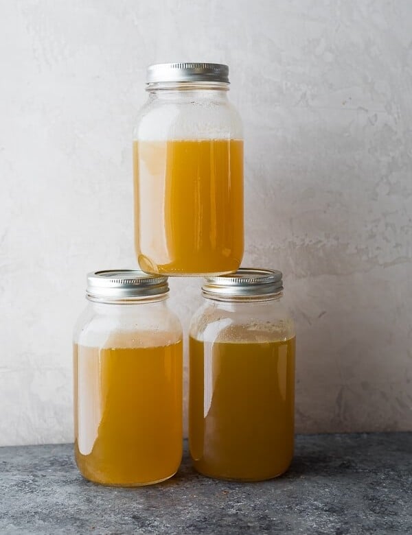 three glass stacked mason jars filled with turkey bone broth