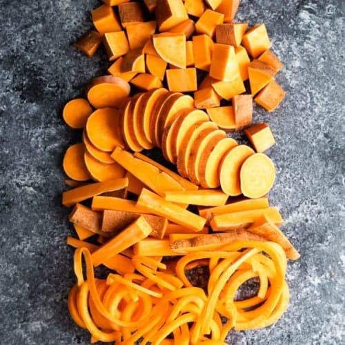 overhead shot of sweet potatoes cut in multiple ways on gray background